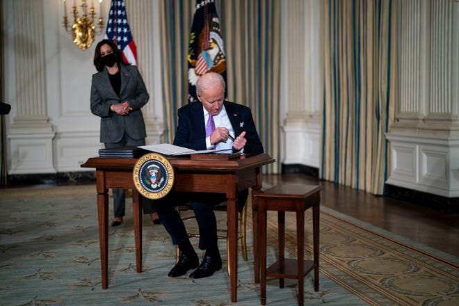 La vice-présidente Kamala Harris regarde le président Joe Biden signer les décrets liés à son programme d'équité raciale le 26 janvier 2021.