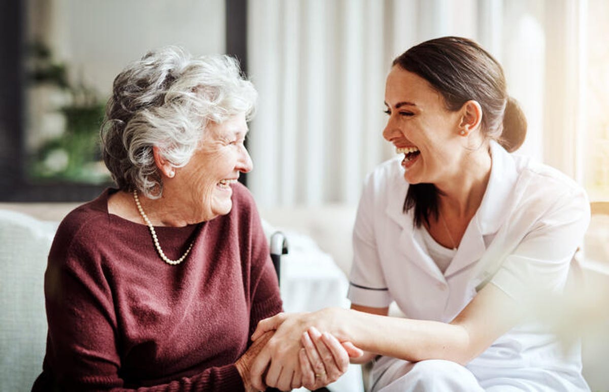 Femme plus âgée riant avec un membre de sa famille.