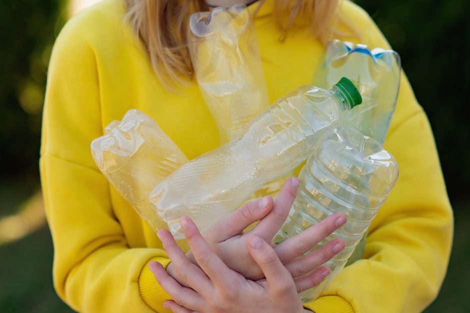 Femme tenant plusieurs bouteilles d'eau vides