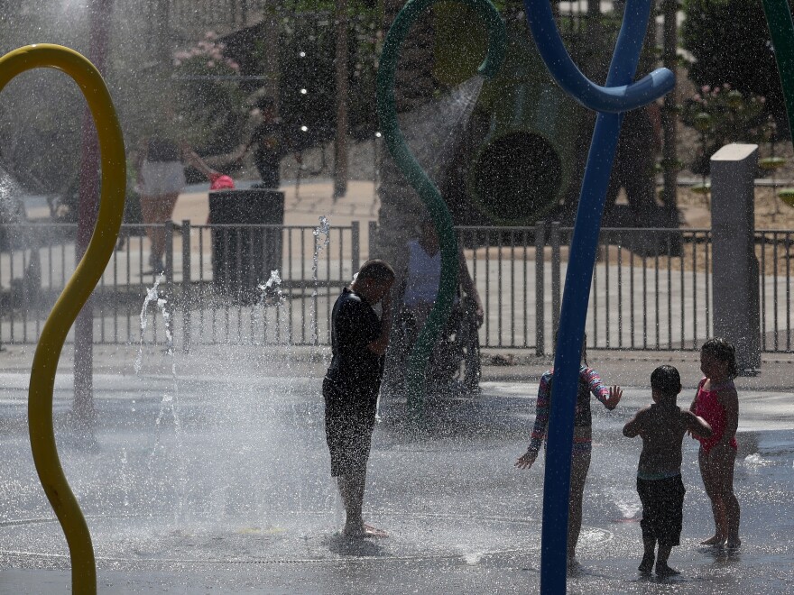 Les enfants jouent dans une pataugeoire au parc Riverview mercredi à Mesa, en Arizona. Les experts avertissent de s'assurer que toute période de jeu en plein air comprend beaucoup d'eau et d'ombre - et s'éloigne de la chaleur - pendant une vague de chaleur prolongée. 