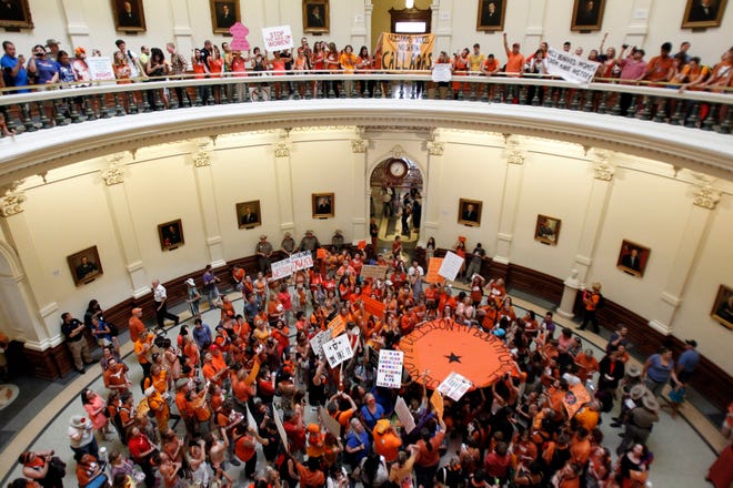 Le droit à l'avortement (en orange) et les défenseurs de l'avortement (en bleu) se rassemblent dans la rotonde du Capitole de l'État, alors que le Sénat de l'État se réunit pour examiner une législation restreignant le droit à l'avortement à Austin, Texas, le 12 juillet 2013. Mike Stone, Reuters.