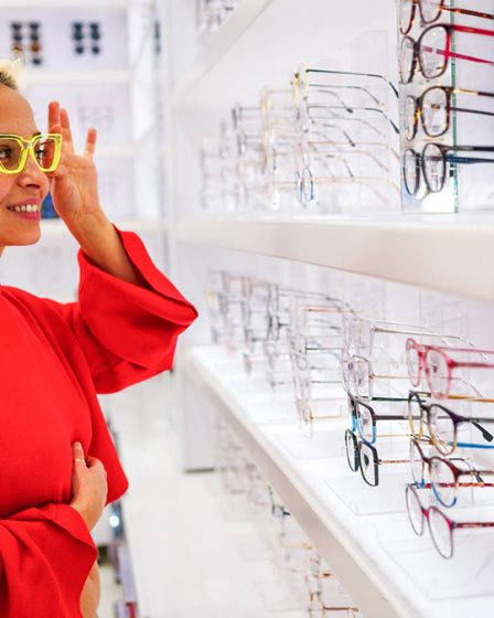 woman trying on optical glasses in store