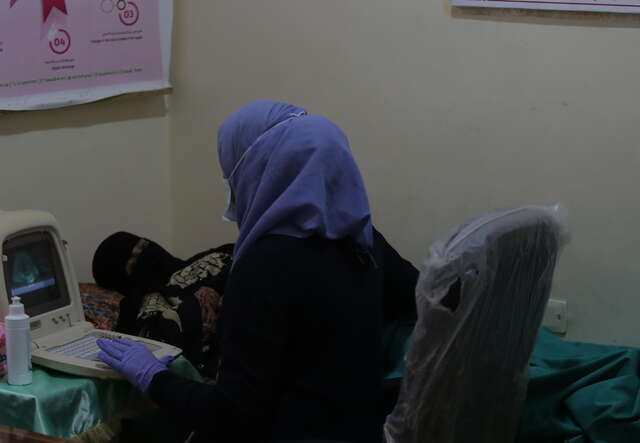 Une infirmière effectue un examen prénatal sur une femme dans une clinique de santé.