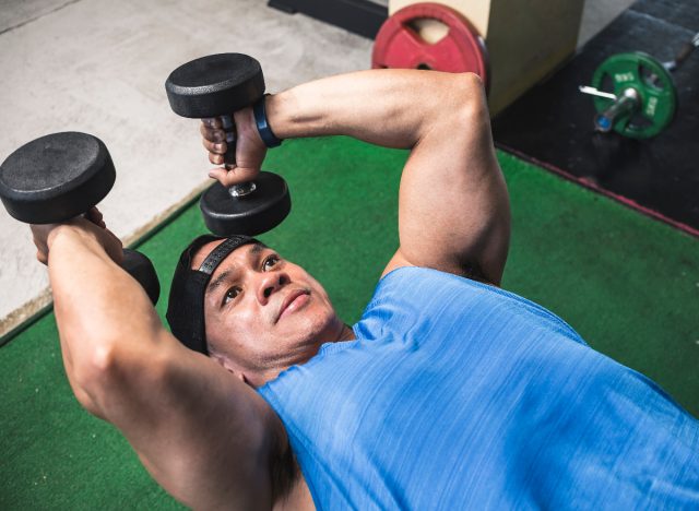 man performing skull crusher exercise in arms workout